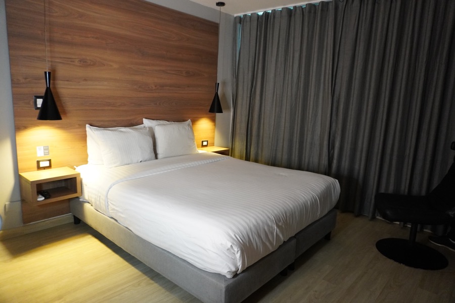 Double room with a king bed, wooden headboard and curtains